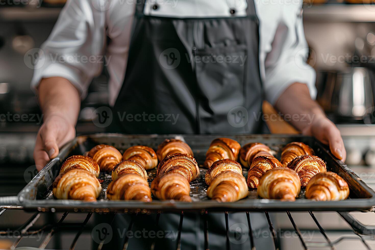 Koch Hände halten Backen Tablett mit frisch Croissants. foto