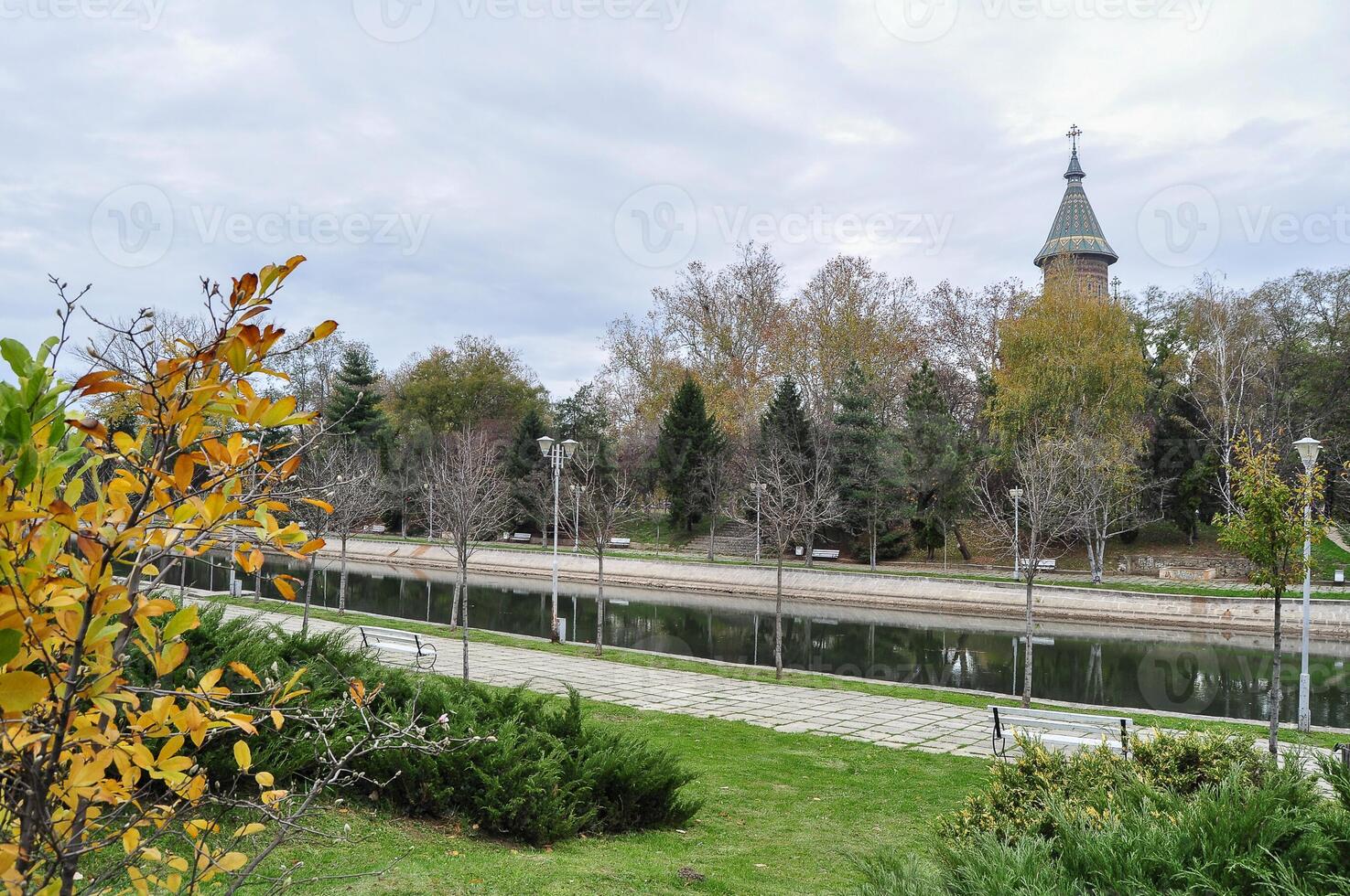 Herbst auf das Ufer von Fluss bega.wunderschön Park im begann Kanal und orthodox Kathedrale im das Hintergrund. Park Bäume reflektieren im das Wasser während ein sonnig Tag foto