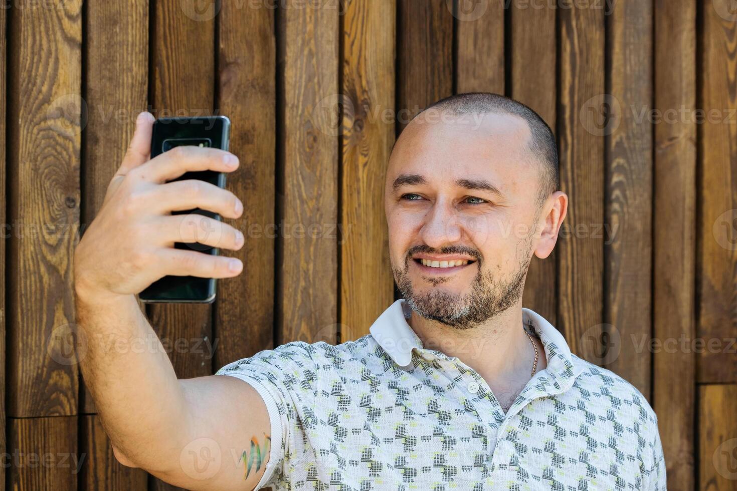 Mann nehmen Selfie gegen hölzern Mauer foto