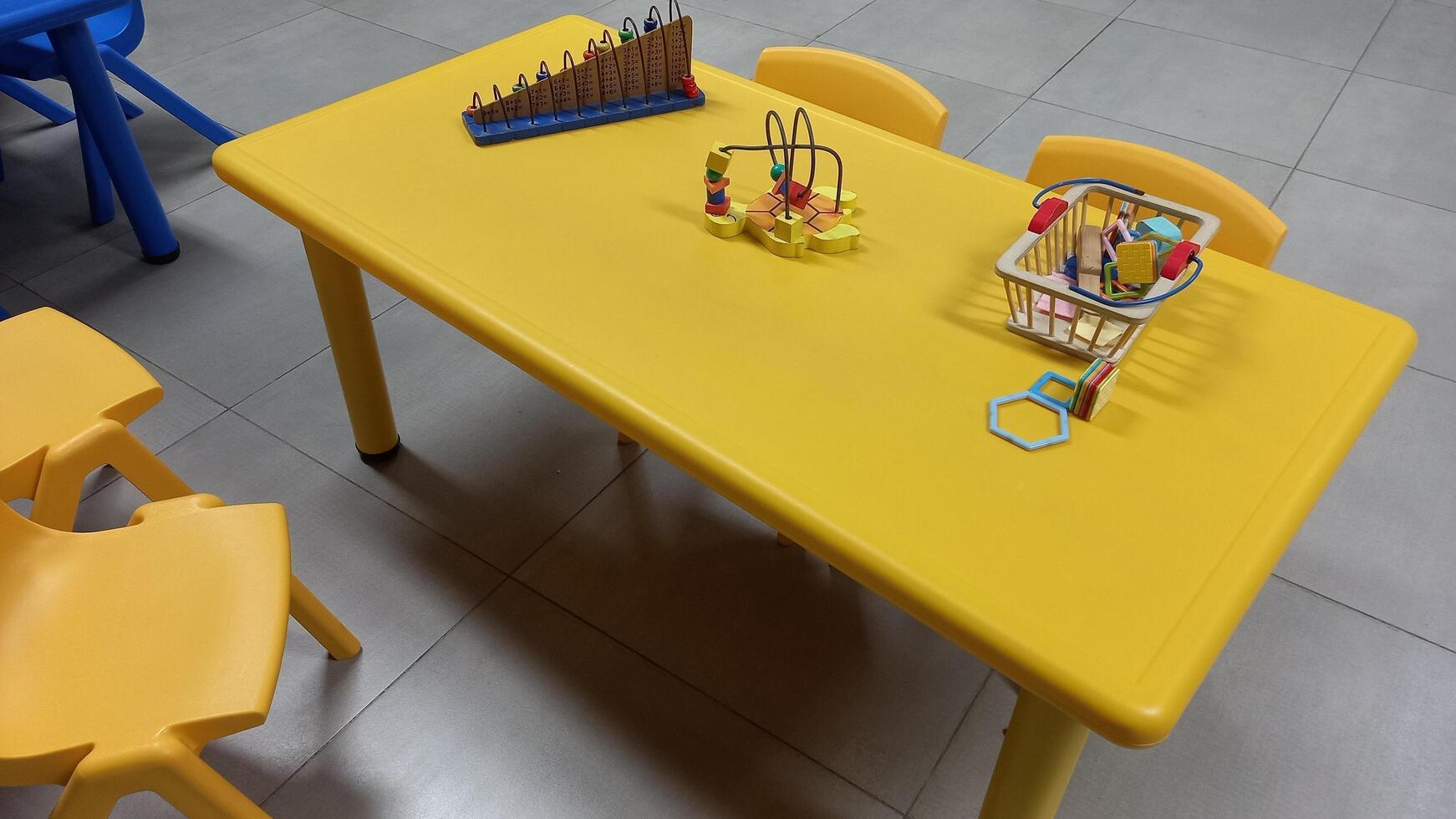 ein Gelb Tabelle mit ein Stuhl und ein Spielzeug foto