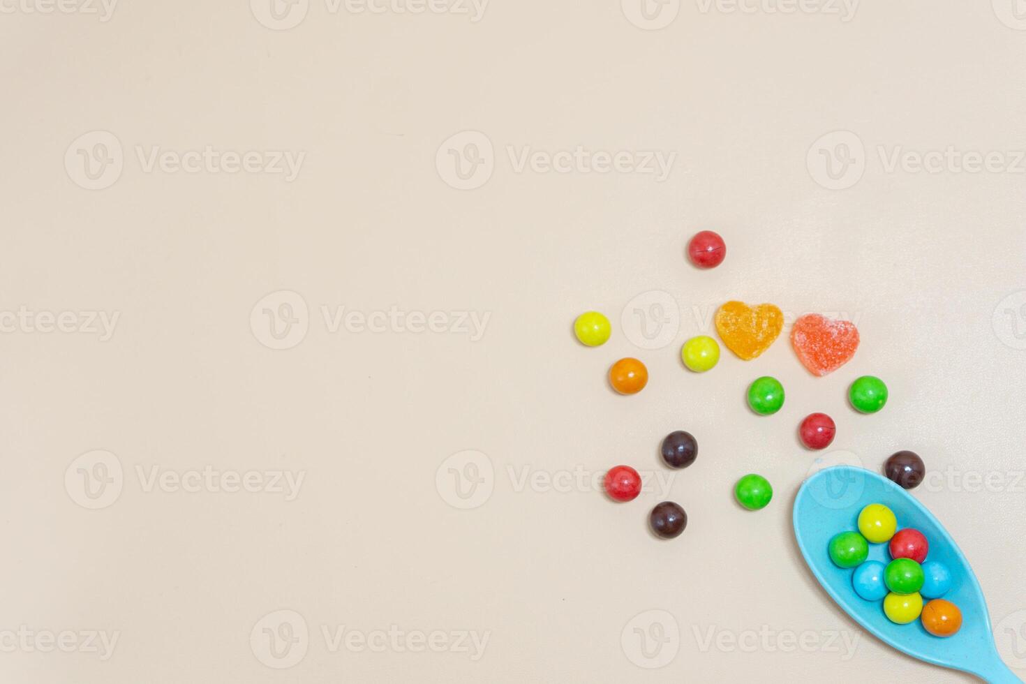 Herz geformt Süßigkeiten und multi farbig Marmor Süßigkeiten mit Löffel auf isoliert auf Weiß Hintergrund. foto