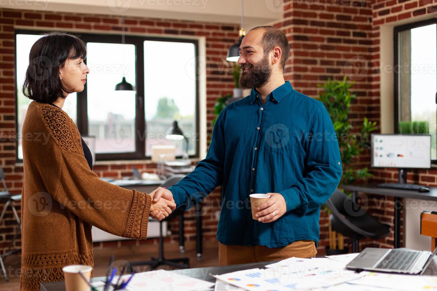 Geschäftsteam beim Händeschütteln während des Firmenmeetings im Startup-Büro foto