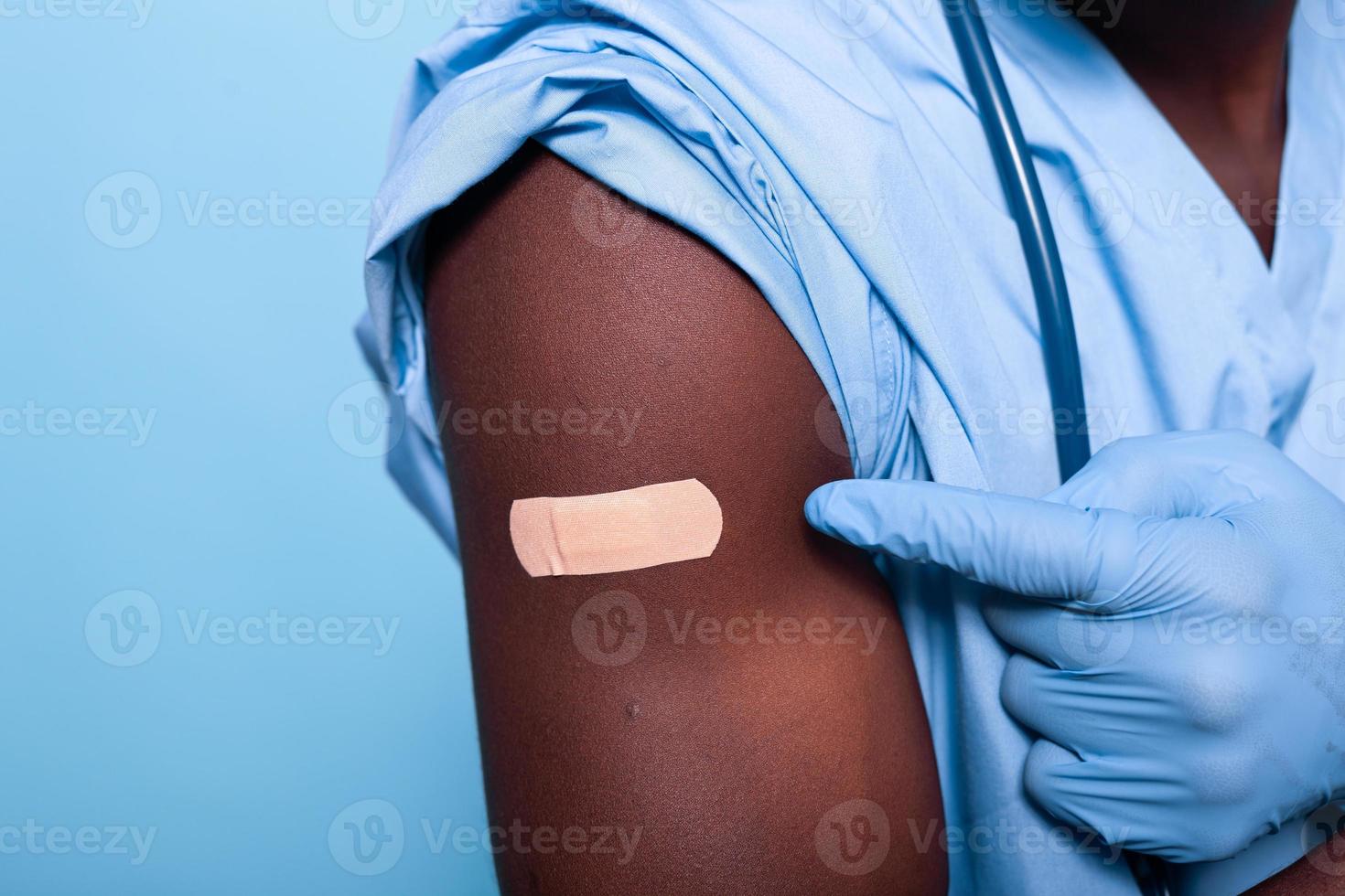 Nahaufnahme eines bandagierten Impfstoffs, der auf den Arm der Krankenschwester geschossen wurde? foto