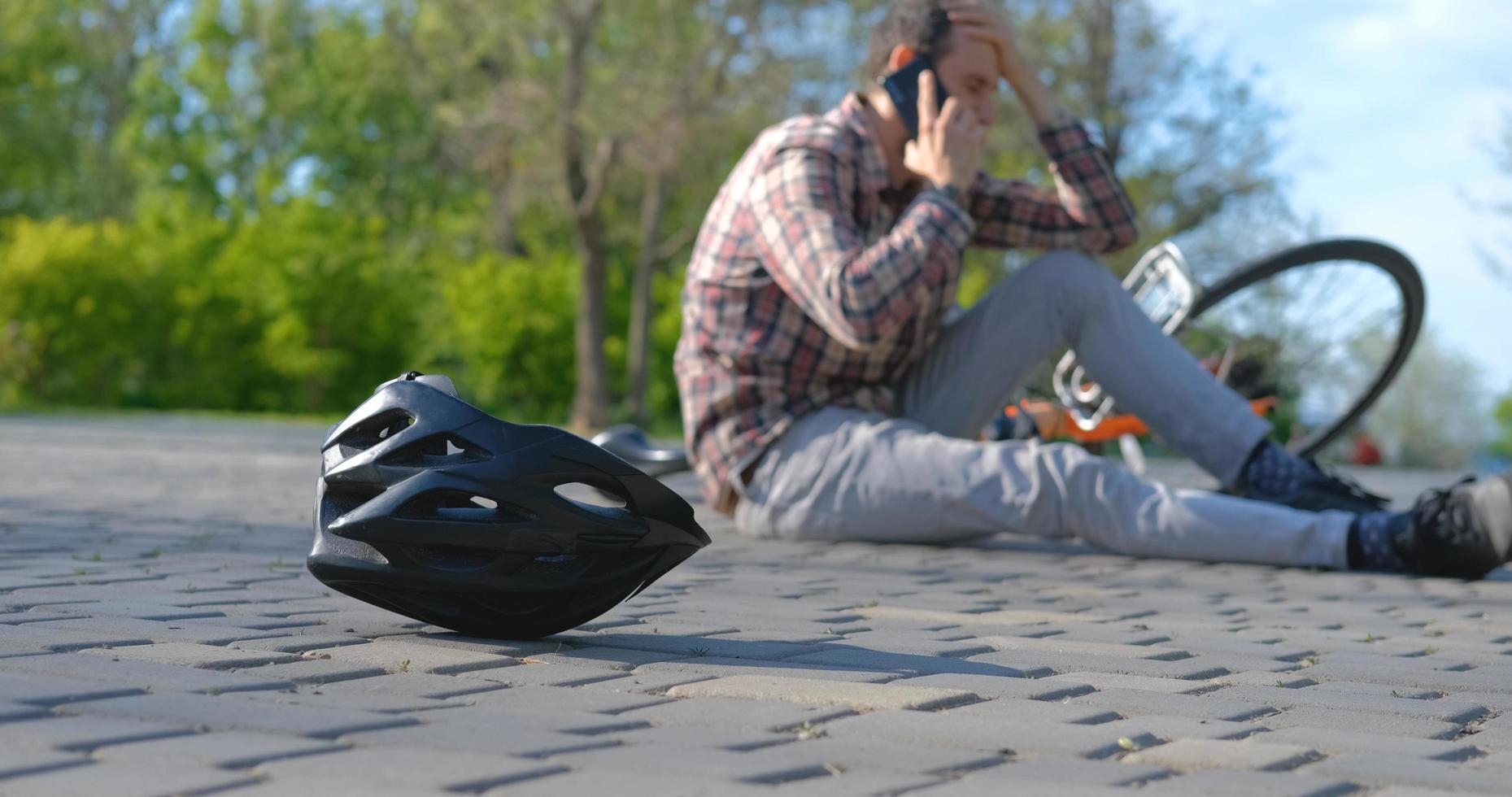 junger Mann in Freizeitkleidung ist im Park vom Fahrrad gefallen foto