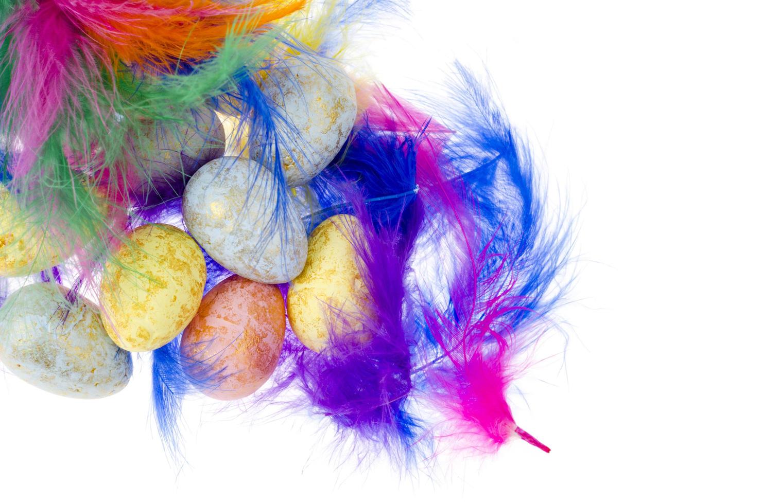 dekorative farbige Eier und Federn auf weißem Hintergrund foto