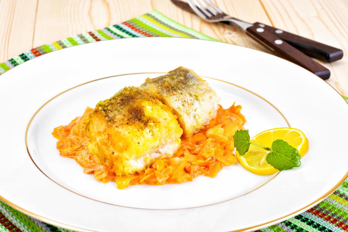 Fisch auf Griechisch mit Zwiebeln und Karotten foto