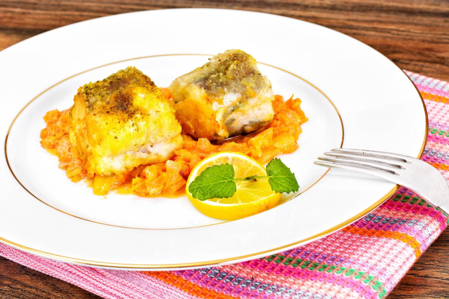 Fisch auf Griechisch mit Zwiebeln und Karotten foto