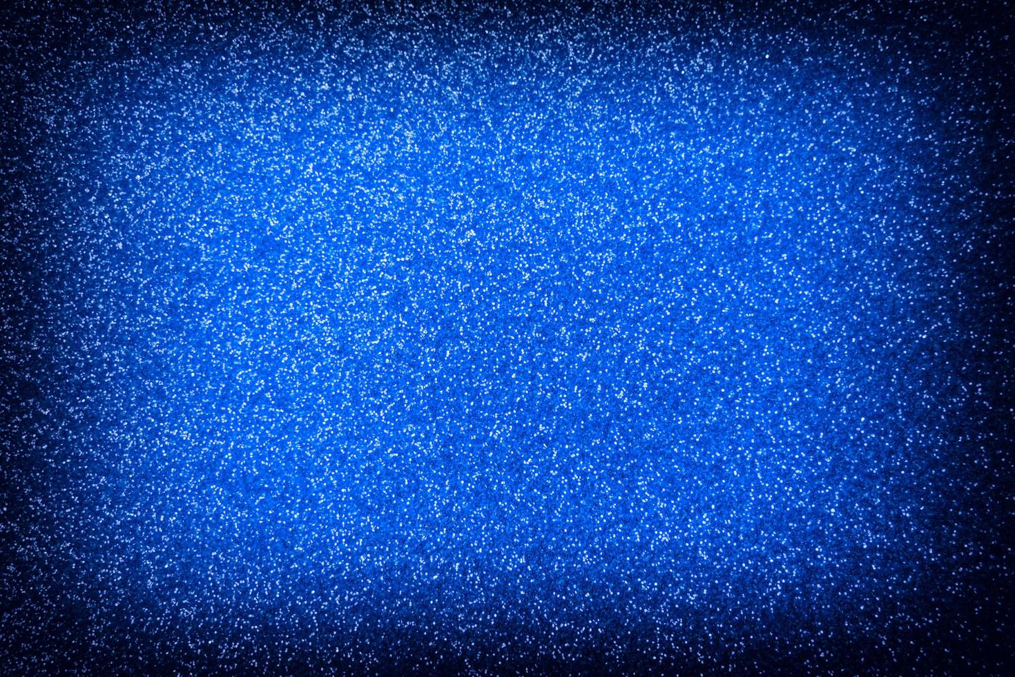 blauer glänzender Hintergrund mit weißen kleinen Pailletten, dunkle Vignette foto