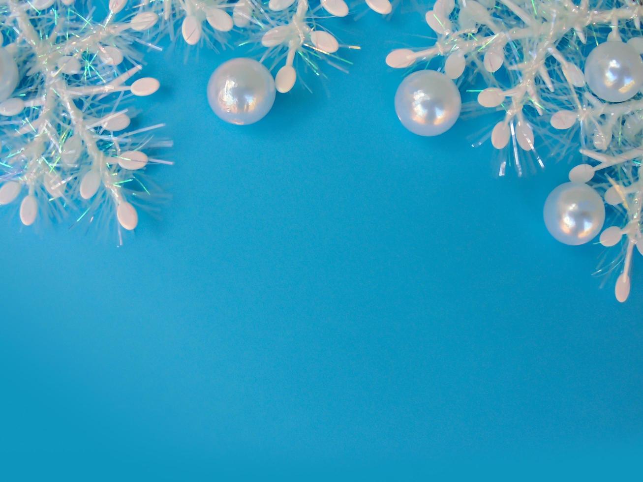blauer Weihnachtshintergrund mit weißen Schneeflocken und Perlmuttperlen. Platz kopieren foto