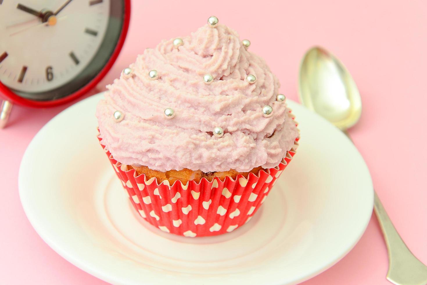 Kuchen mit Sahne, Cupcake auf rosa Hintergrund. foto