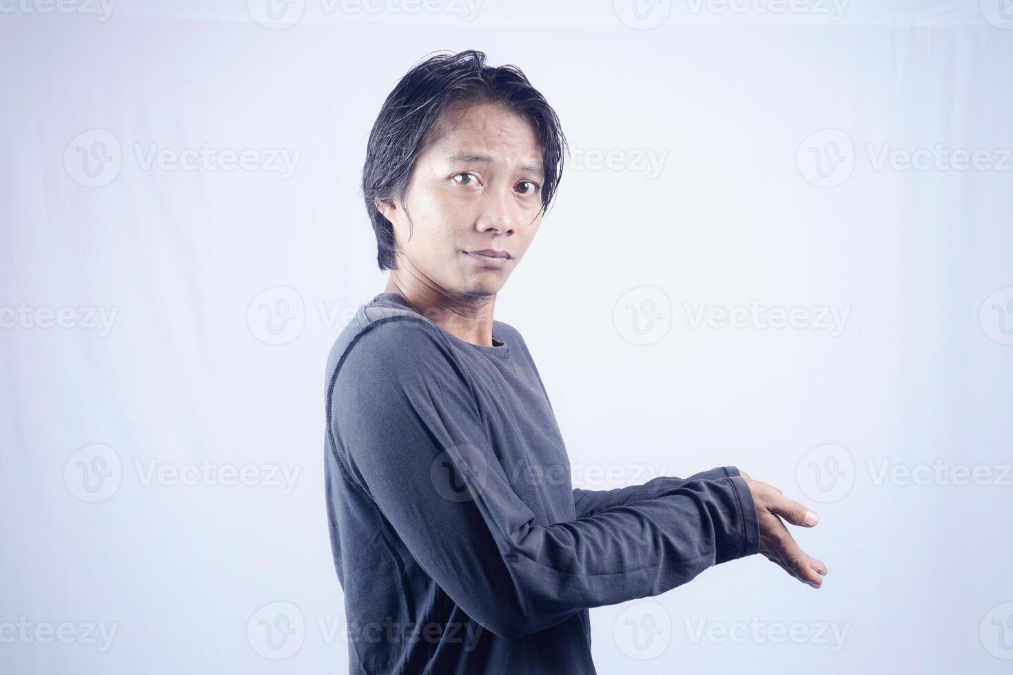 gut aussehend asiatisch Mann gegenüber das Kamera ist zeigen beim das Kopieren Raum zum Werbung auf ein isoliert Weiß Hintergrund. foto