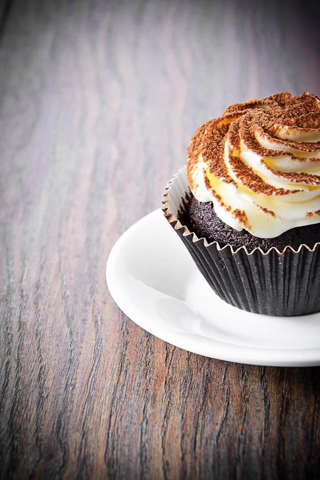 Kuchen mit Sahne, Cupcake auf holzigem Hintergrund foto