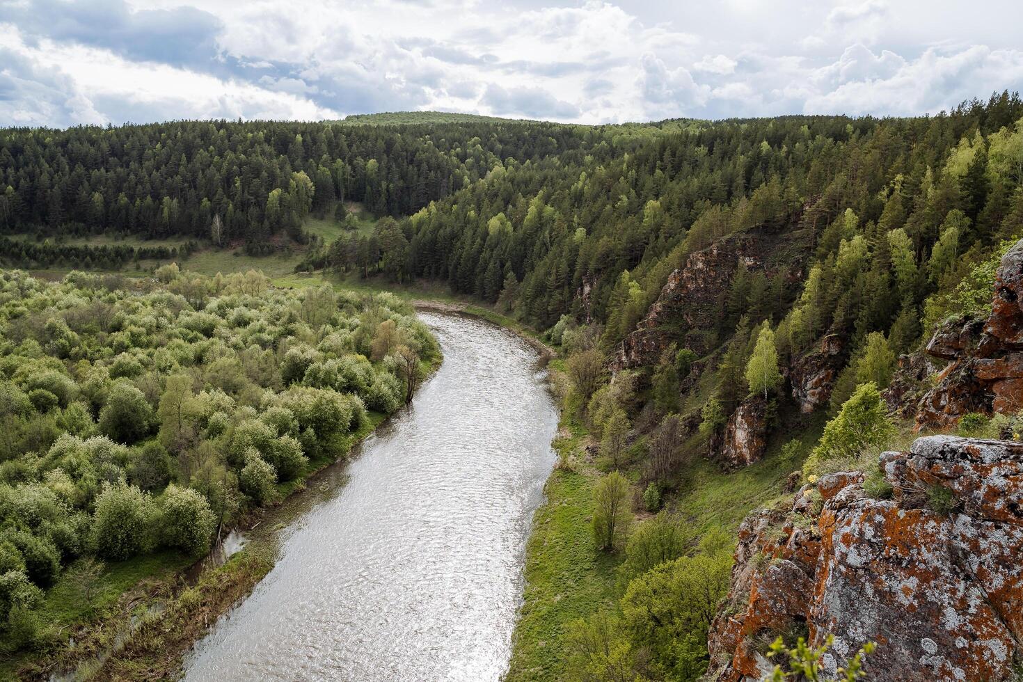 das Natur von Russland, das Taiga Bereich, das reserviert Land, das Landschaft von das Berg Fluss, das Orange Felsen gegen das Hintergrund von das Grün Wald, das bedeckt Himmel. foto