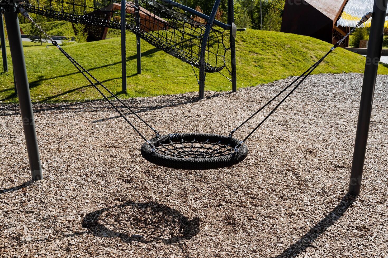 Schaukeln zum Kinder hängen auf Stangen, ein Spielplatz, ein schwarz Seil flechten, ein Platz zum Gehen mit Kinder, ein runden hängend schwingen. foto