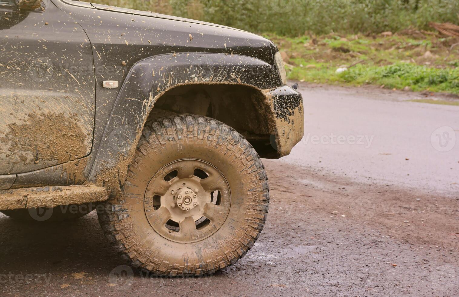 Rad Nahansicht im ein Landschaft Landschaft mit ein Schlamm Straße. Offroad 4x4 suv Automobil mit ditry Körper nach Fahrt im schlammig Straße foto