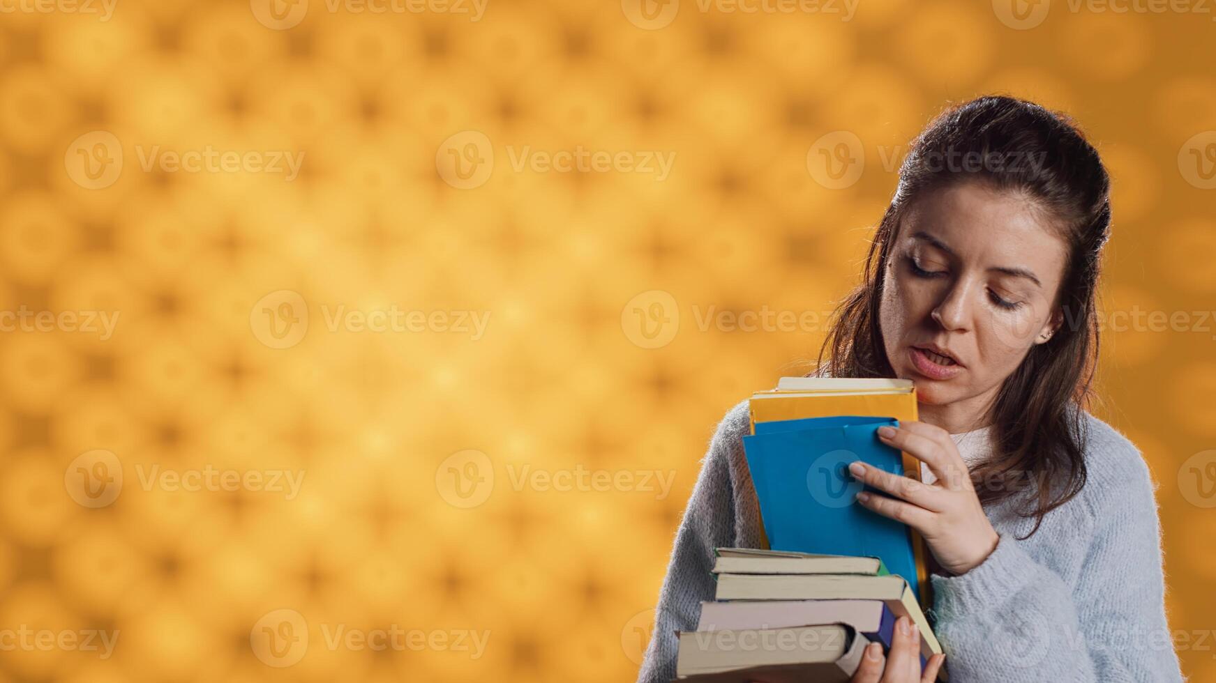 aufgeregt Frau Surfen obwohl Stapel von gekauft Bücher, pflücken Was zu lesen. begeistert Buchsüchtig Person suchen durch Stapel von Romane zu verbringen Freizeit Zeit mit, Studio Hintergrund, Kamera ein foto