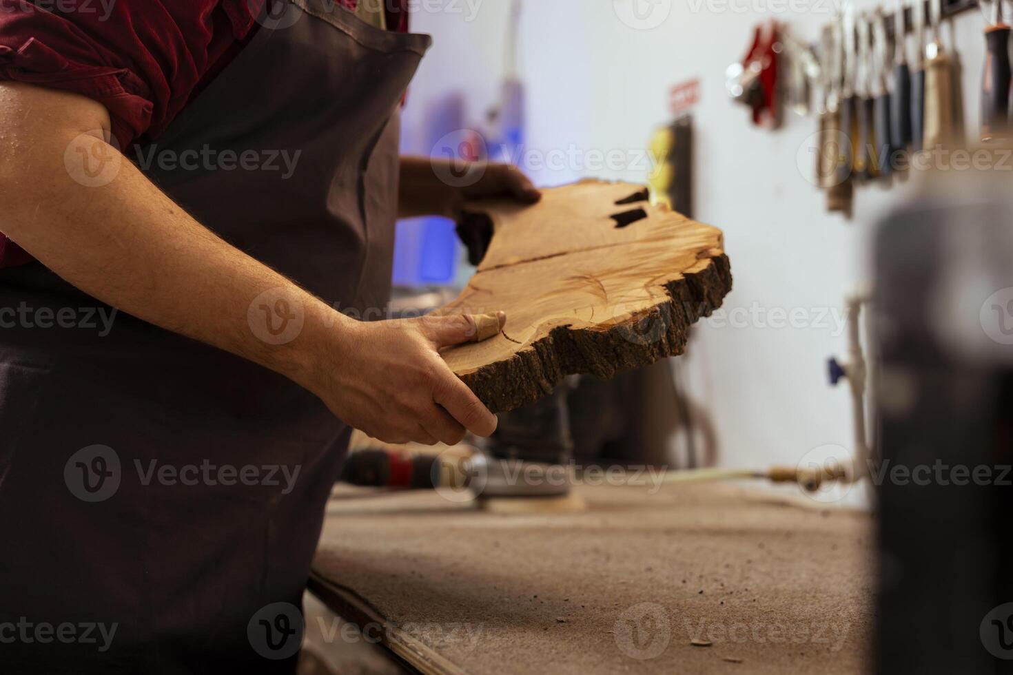 Zimmermann halten Bauholz Block, tun Qualität Sicherheit auf es Vor beginnend Möbel Montage im Werkstatt, schließen oben Schuss. Hersteller im Tischlerei vorbereiten Stück von Holz zum Carving foto