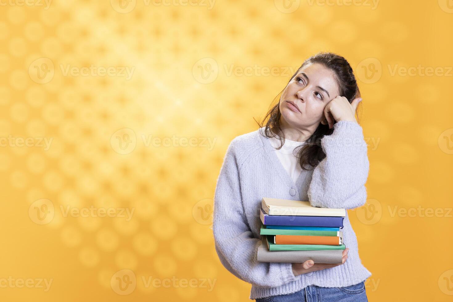 Porträt von entspannt Frau Tagträumen während halten Stapel von Bücher, genießen lesen Hobby. Person mit Stapel von Romane im Waffen gefangen im Träumereien während genießen Freizeit Zeit, Studio Hintergrund foto