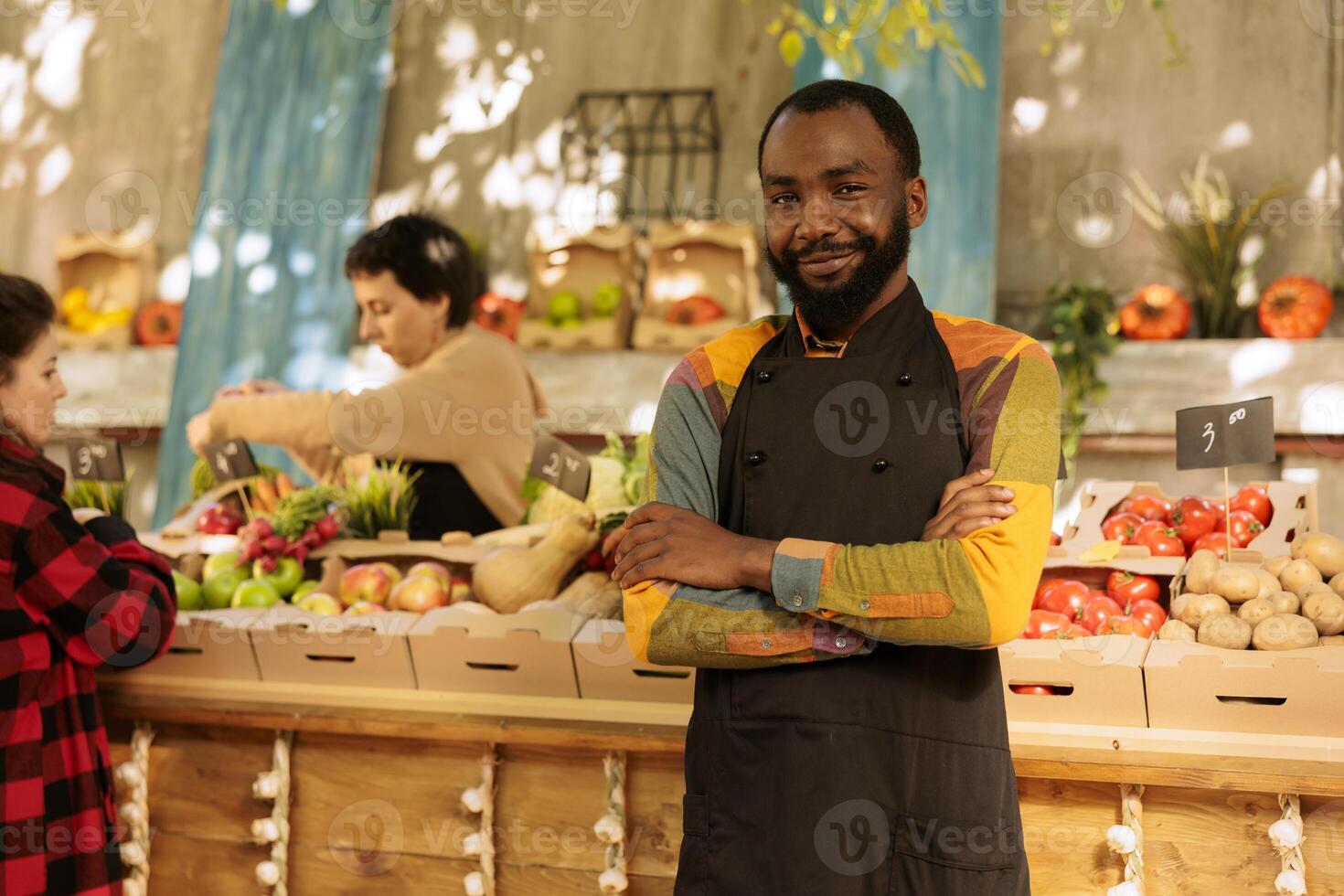 Bauern Markt Verkäufer Verkauf gesund organisch Produkte Nächster zu Essen Marktplatz Stall. jung Mann mit saisonal örtlich gewachsen Gemüse und frisch natürlich Früchte und Gemüse. foto