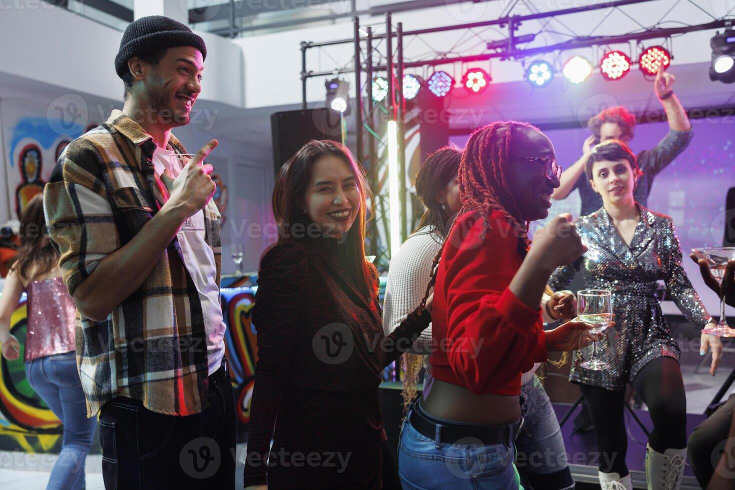 sorglos lächelnd Menschen Trinken Alkohol Getränk und haben Spaß beim Disko Party im Nachtclub. heiter jung freunde feiern und genießen Nachtleben Freizeit Aktivität im Verein foto