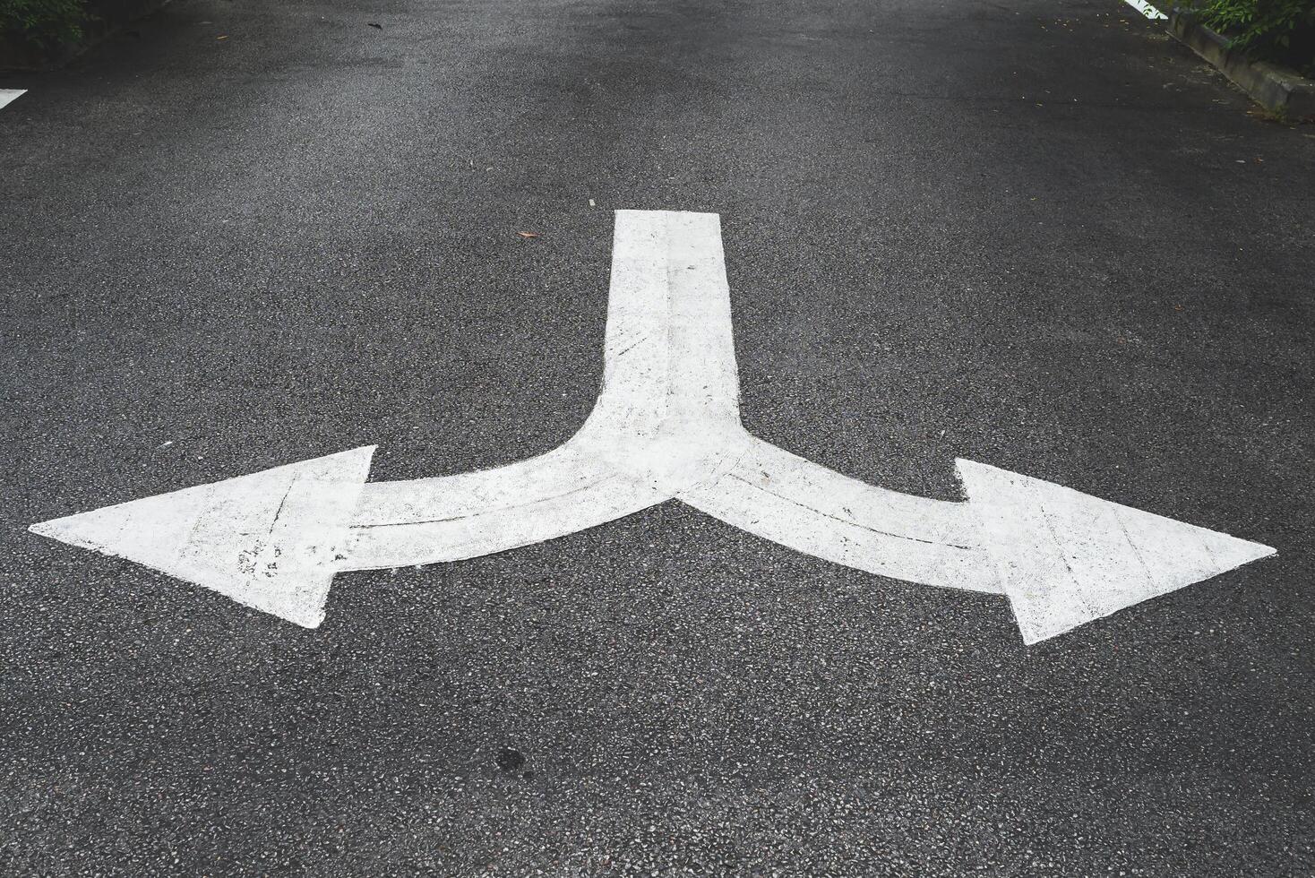 Weiß Pfeil Symbole zeigen links und richtig geben Richtungen auf das Straße. foto