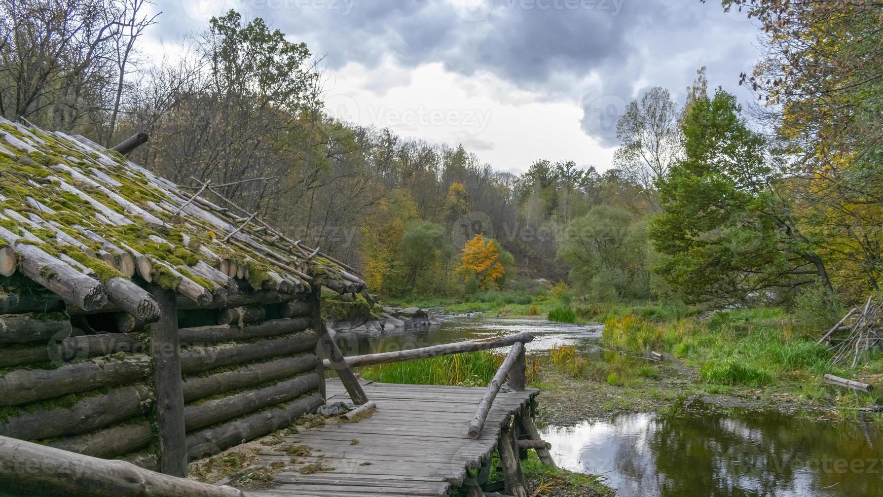 alte Holzhütte im herbstlichen Wald mit Blättern bestreut foto