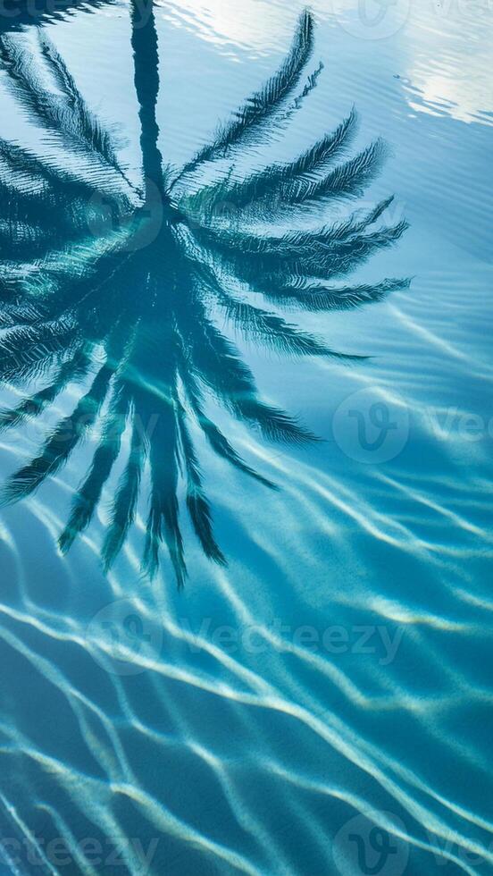 Schatten von Palme Blätter auf plätschern Blau Wasser Oberfläche, tropisch Hintergrund foto