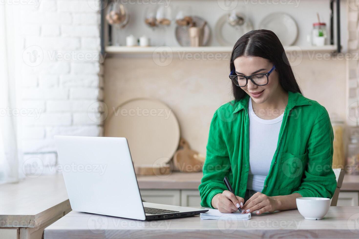 ein jung Frau Journalist, Schriftsteller, Blogger funktioniert entfernt von Zuhause mit ein Laptop online und Anmerkungen foto