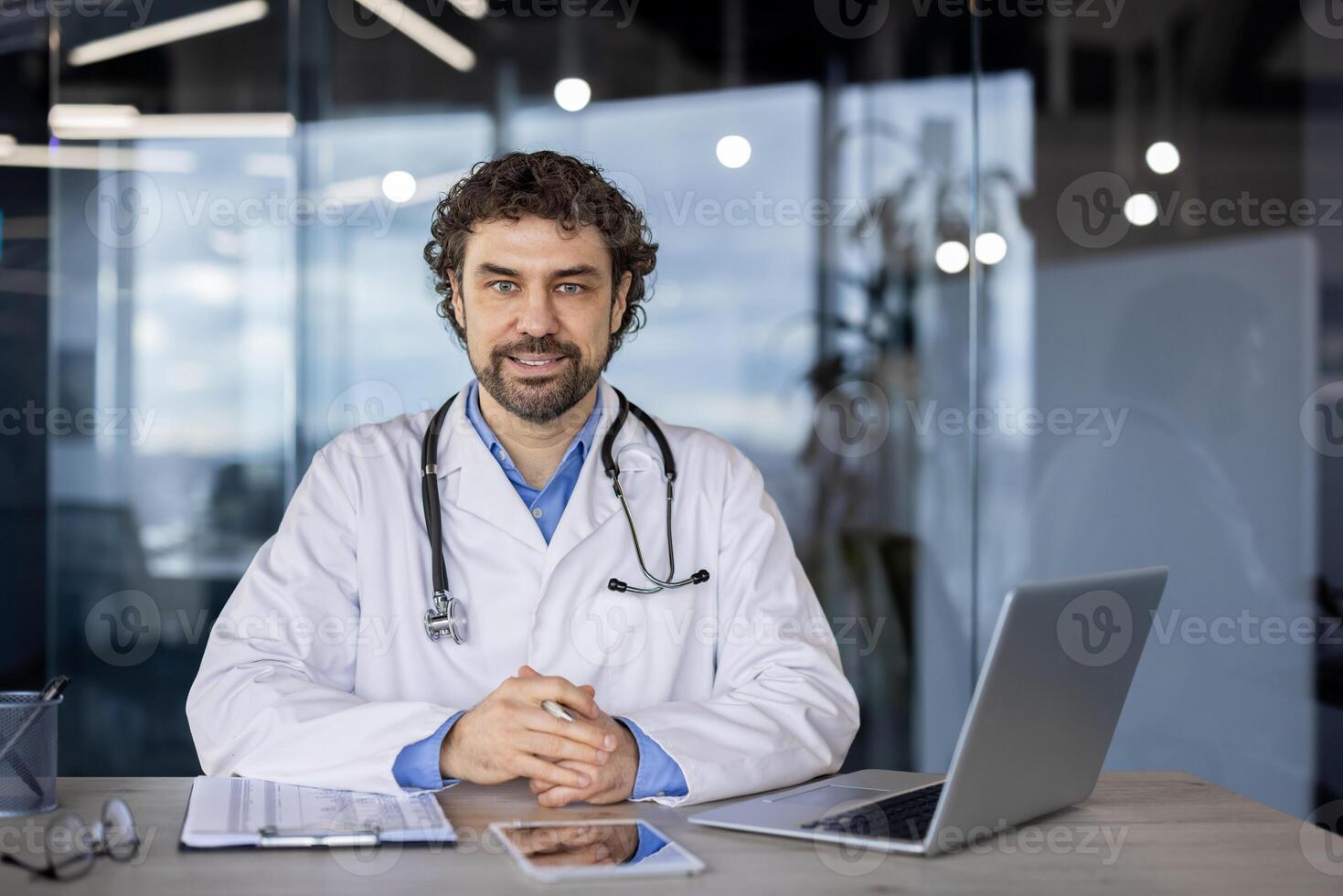 Fachmann männlich Arzt mit ein Stethoskop um seine Hals Sitzung im ein modern Klinik Büro, erscheint zuversichtlich und zugänglich. foto