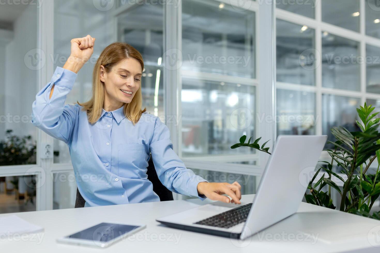 ein froh weiblich Mitarbeiter feiert Erfolg mit ein tanzen beim ihr Arbeitsplatz, zeigen Begeisterung und Positivität im das Büro. foto