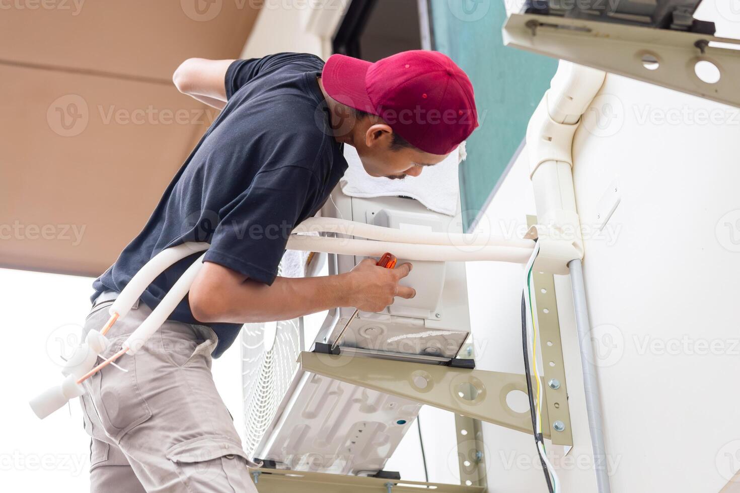 Handwerker Bedienung zum Reparatur und Instandhaltung von Luft Conditioner, Techniker Mann Installieren Neu Luft Conditioner foto