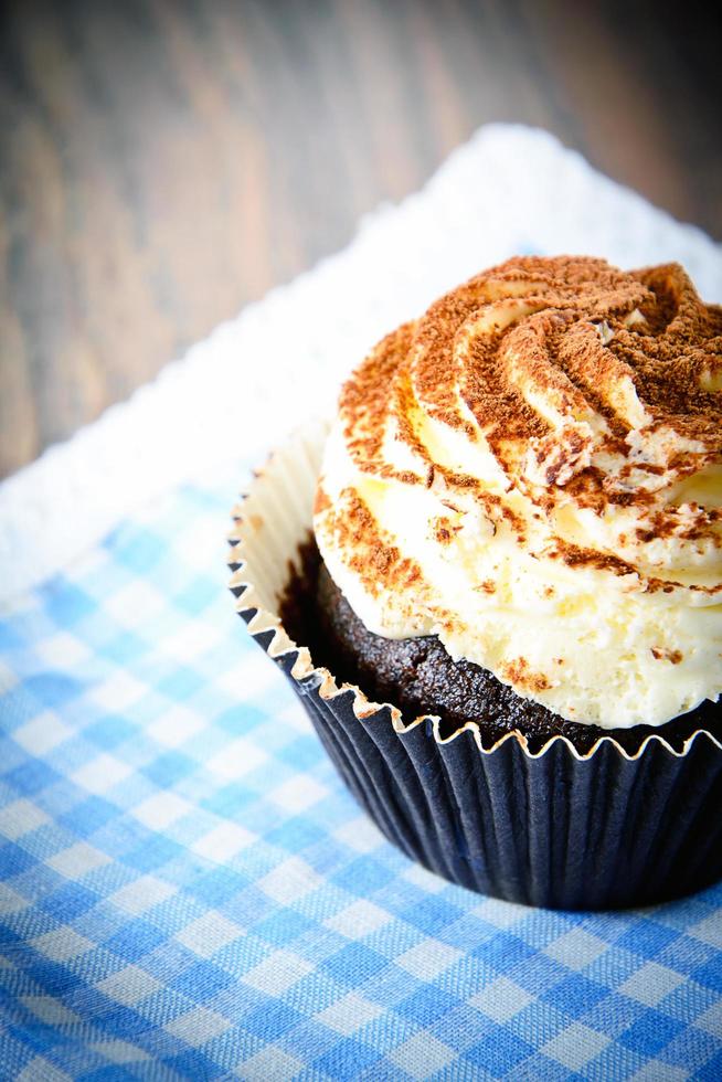 Kuchen mit Sahne, Cupcake auf holzigem Hintergrund. foto