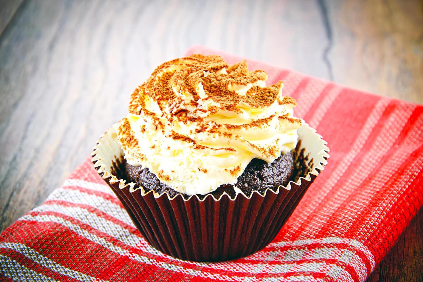 Kuchen mit Sahne, Cupcake auf holzigem Hintergrund. foto