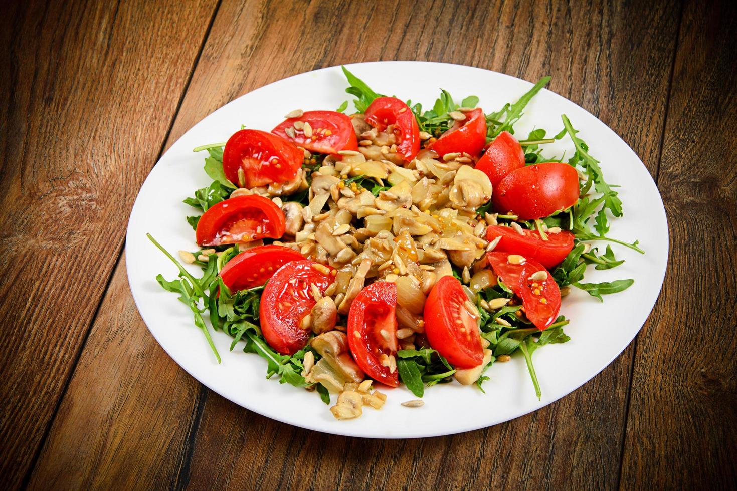 Salat mit Tomaten, Champignons, Rucola und Sonnenblumenkernen foto