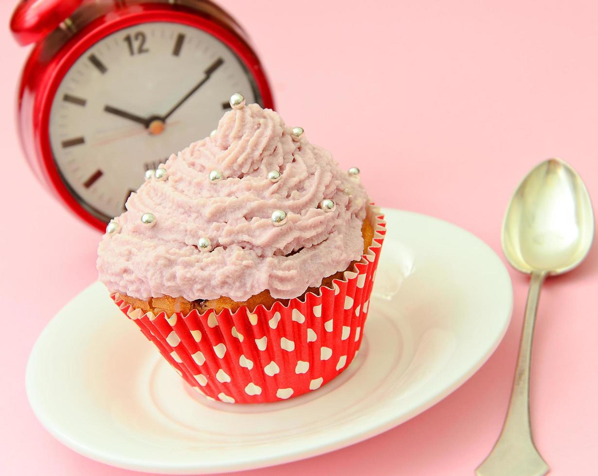 Kuchen mit Sahne, Cupcake auf rosa Hintergrund. foto