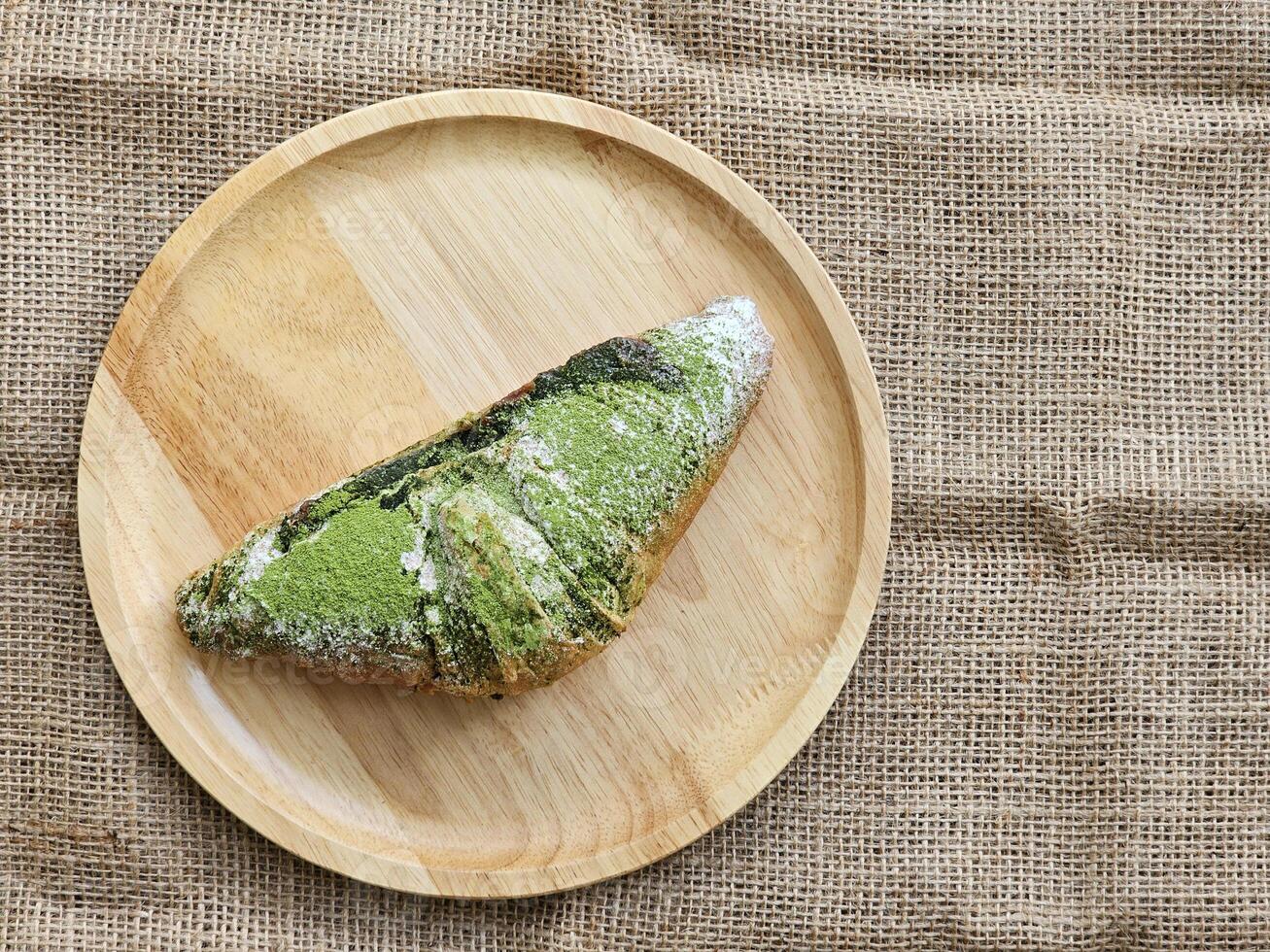 Grün Tee Matcha Croissants ausgestopft mit rot Bohne Einfügen auf hölzern Platte. oben Aussicht foto