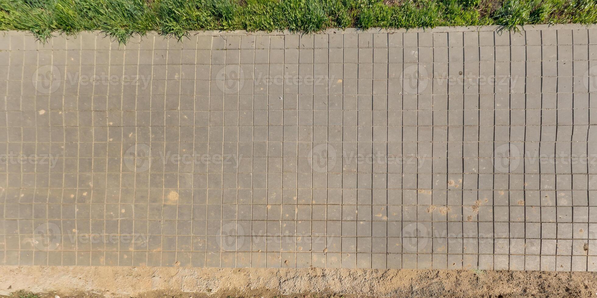 oben Aussicht von das Textur von Pflasterung Platten auf Fußgänger Pfad foto