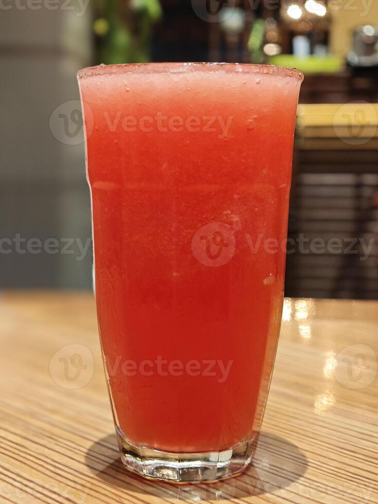 erfrischend Wassermelone Saft im Glas auf hölzern Bar Tabelle foto