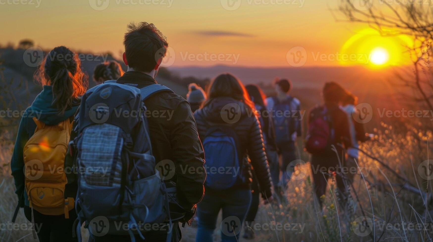 ein Gruppe Wanderung zu ein szenisch Stelle wo Studenten können Uhr das Sonnenaufgang oder Sonnenuntergang zusammen und verbinden mit Natur während ihr Alkoholfrei Frühling brechen foto