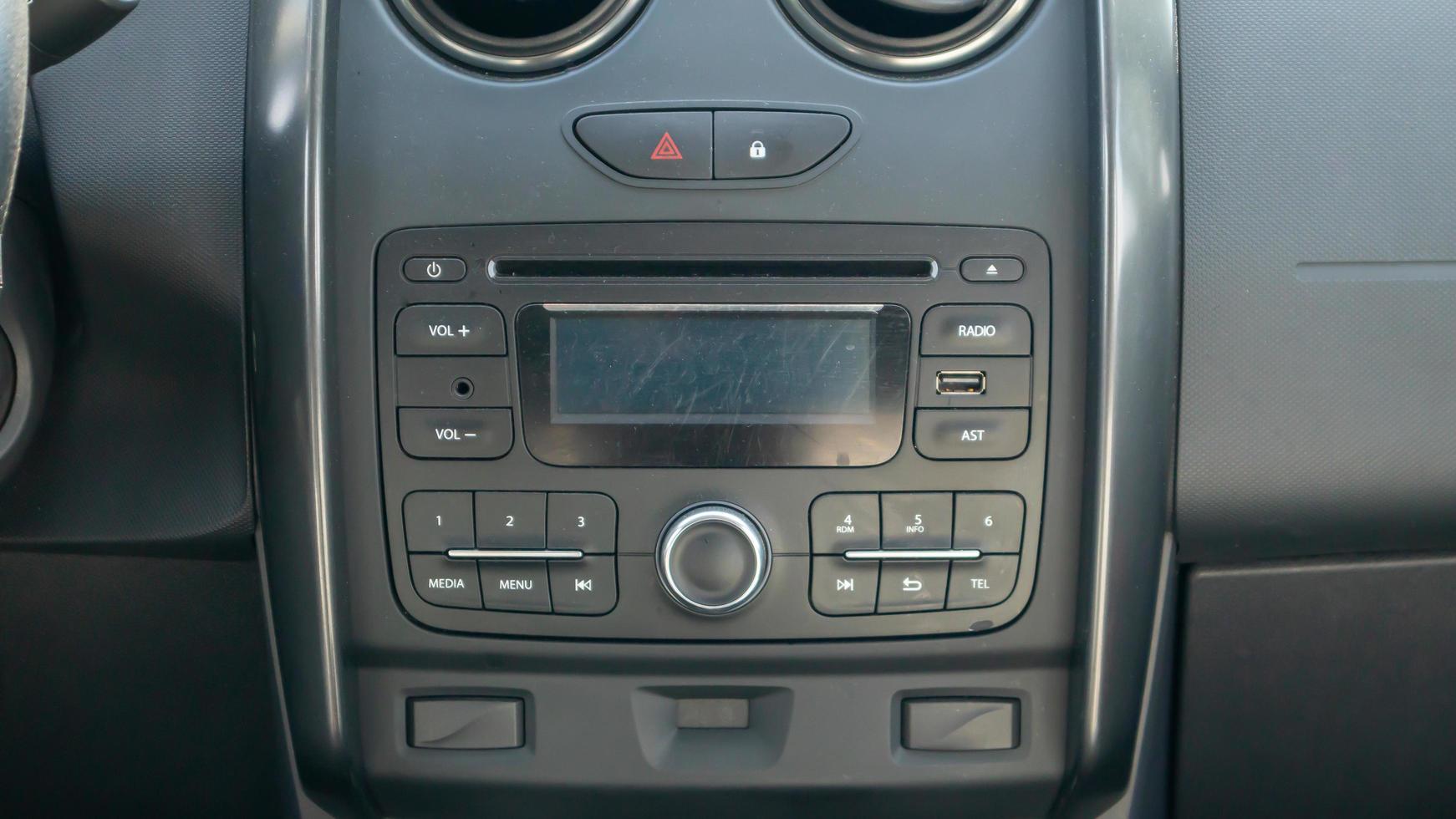 Multimedia im Auto etabliert. Nahaufnahme von Headunit und Radioempfänger mit Display im Auto. Staub und Kratzer sind auf dem Gerätebildschirm sichtbar. Multimedia-System. foto