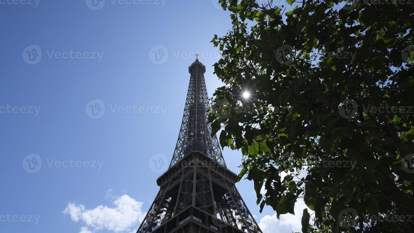 Eiffel Turm schließen hoch, berühmt Paris Französisch Hauptstadt Monument von Stahl im das Stadt Center, Tourist Attraktion und das die meisten hat besucht Wahrzeichen gegen das Blau Himmel im Sonnenlicht, Sonne Balken foto