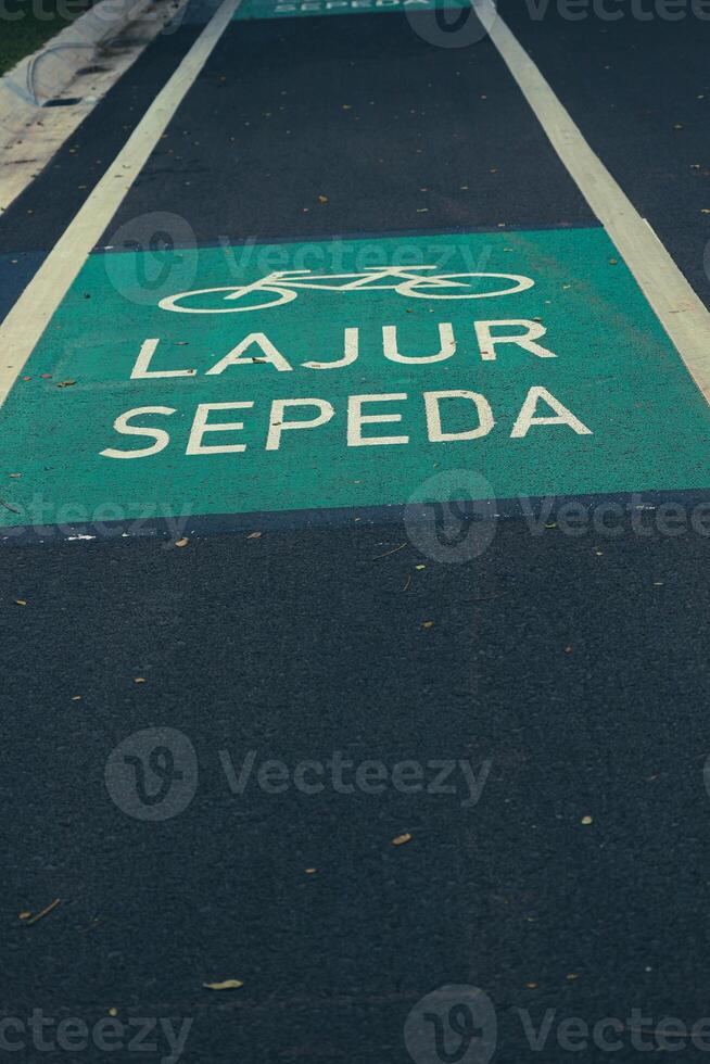 Fahrrad Fahrbahn Zeichen im Gelb mit solide Linien auf Asphalt Straße im Indonesien foto