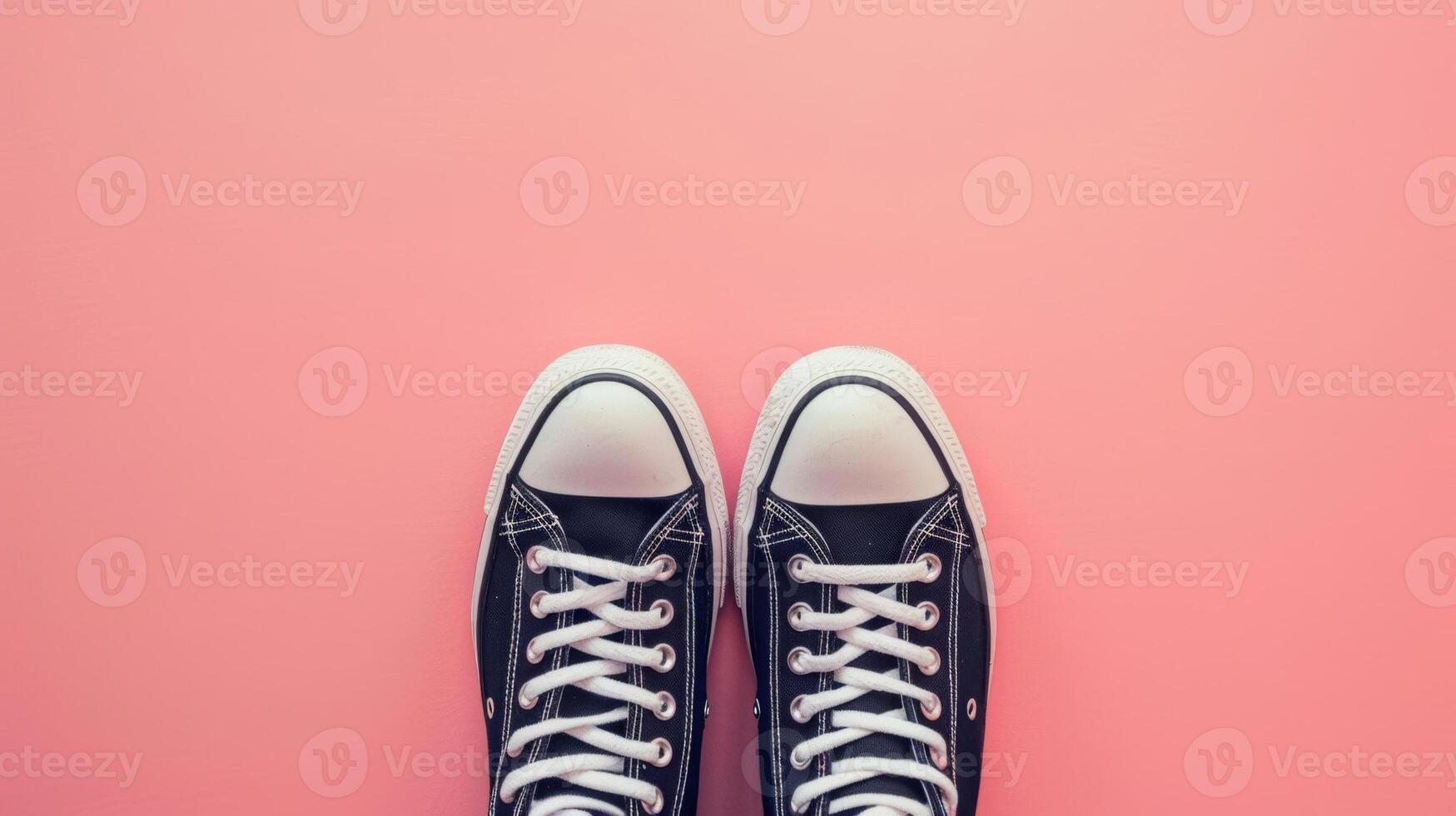 minimalistisch schwarz Turnschuhe auf ein Pastell- Rosa Hintergrund, oben Aussicht mit Kopieren Raum foto