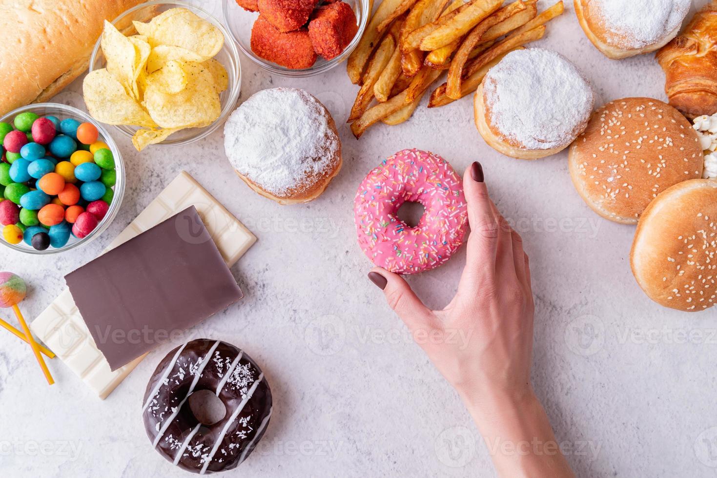 ungesundes Essen und Fast Food mit Donuts, Schokolade, Burgern und Süßigkeiten Draufsicht foto