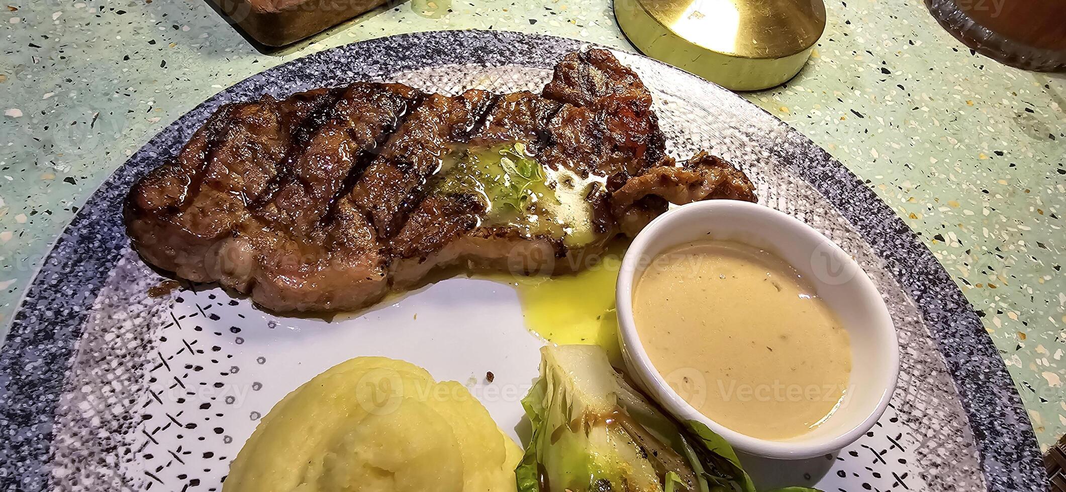 Rindfleisch Neu York Streifen Lende Steak oder Lendenstück Steak serviert mit Kartoffeln, und Pilz Soße und Salat auf Teller foto