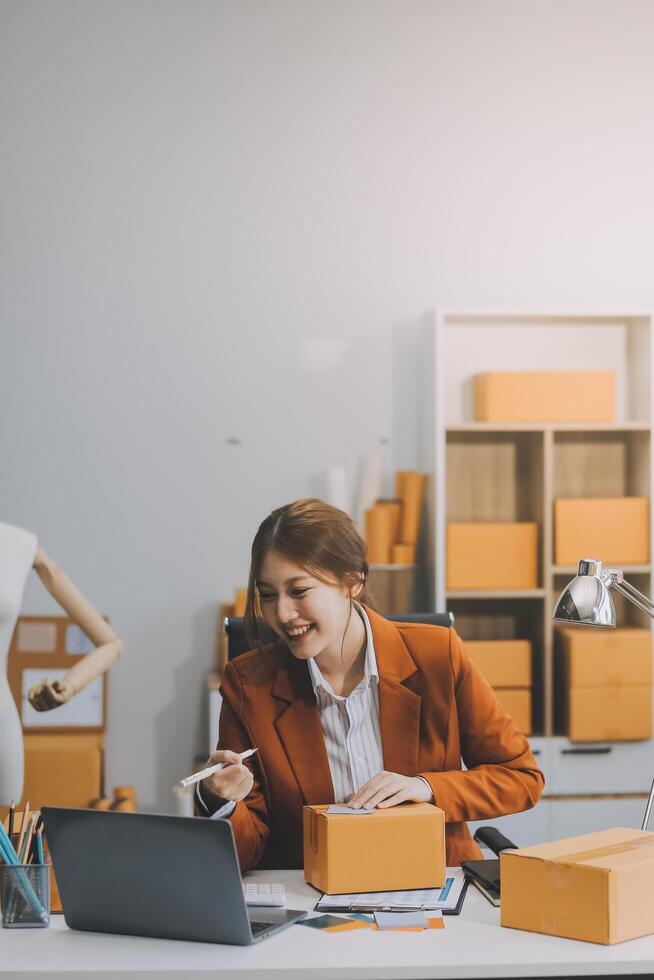 Freiberuflicher Kleinunternehmer, junge Frau im Porträt, die zu Hause im Büro arbeitet, Box, Smartphone, Laptop, Online, Marketing, Verpackung, Lieferung, KMU, E-Commerce-Konzept foto