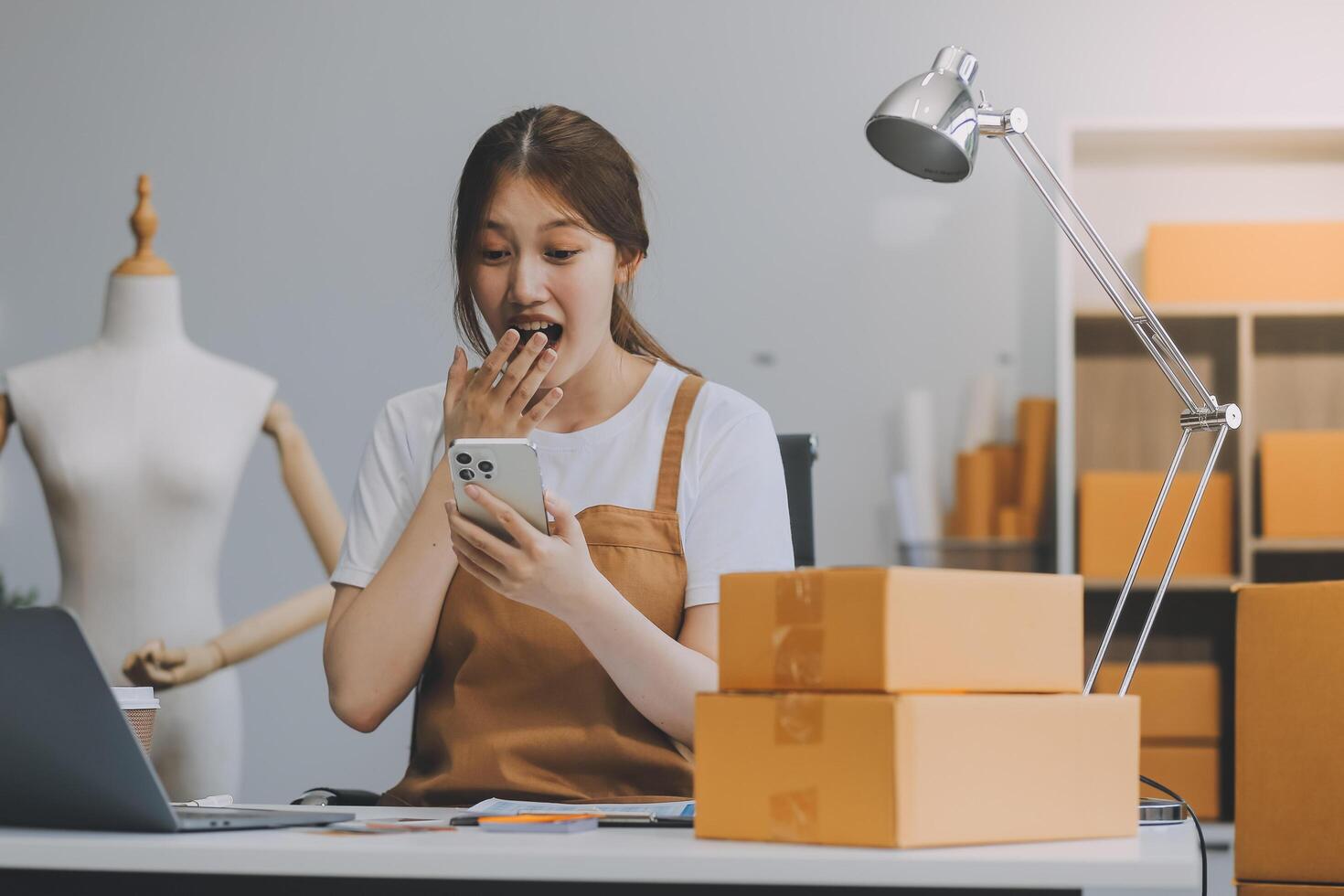 beginnend klein Geschäft Unternehmer sme freiberuflich, Porträt jung Frau Arbeiten beim Zuhause Büro, Kasten, Smartphone, Laptop, online, Marketing, Verpackung, Lieferung, b2b, klein, E-Commerce Konzept.. foto