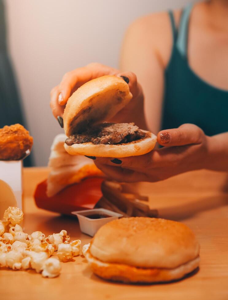 schnell Essen, Menschen und ungesund Essen Konzept - - schließen oben von Frau Hände halten Hamburger oder Cheeseburger foto