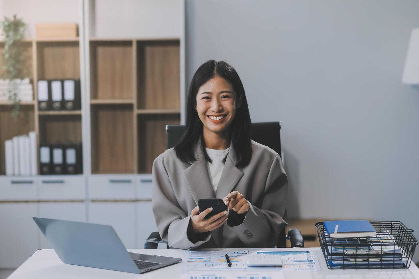 glück unternehmer schönes geschäft asiatische junge frau tragen lässiges handy zum online einkaufen genießen sie mit social media und laptop zu hause. kleinunternehmen startup. online banking foto