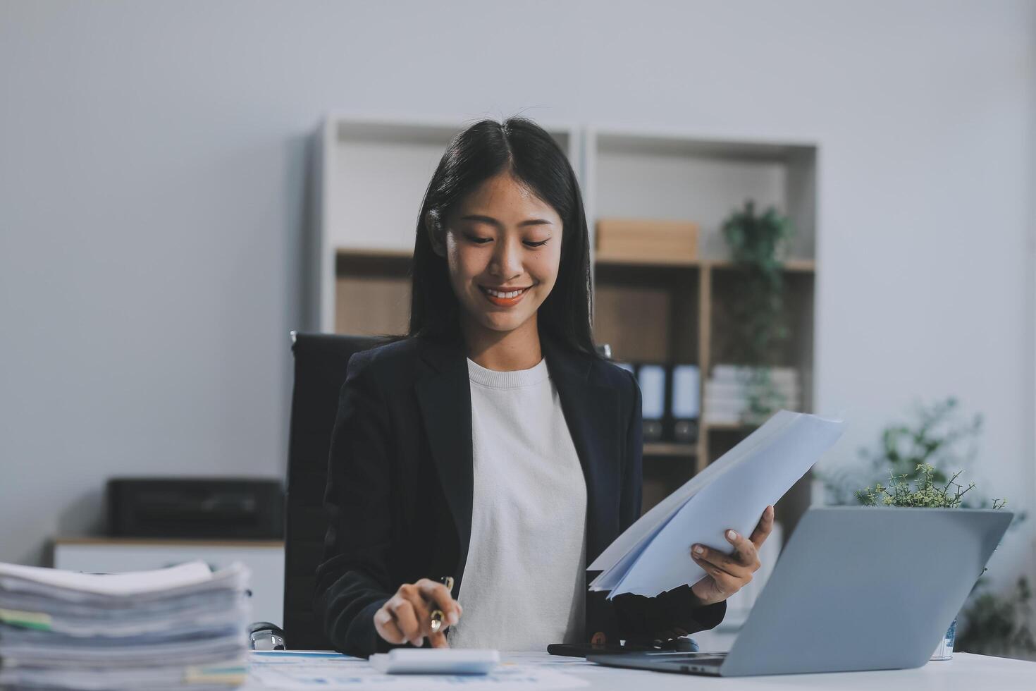 zuversichtlich tausendjährig indisch weiblich Geschäft Analytiker finanziell Berater vorbereiten Statistik Bericht studieren Unterlagen auf Arbeit Schreibtisch, Surfen Information online mit PC, Schreiben aus Anmerkungen auf Papier Blatt foto